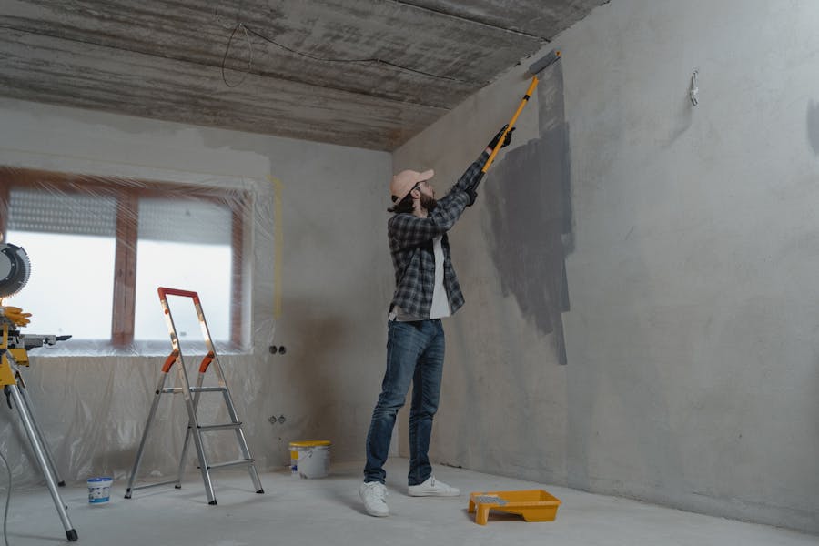 A decorator painting a wall with a roller